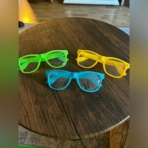 Three non-prescription fun neon costume glasses.